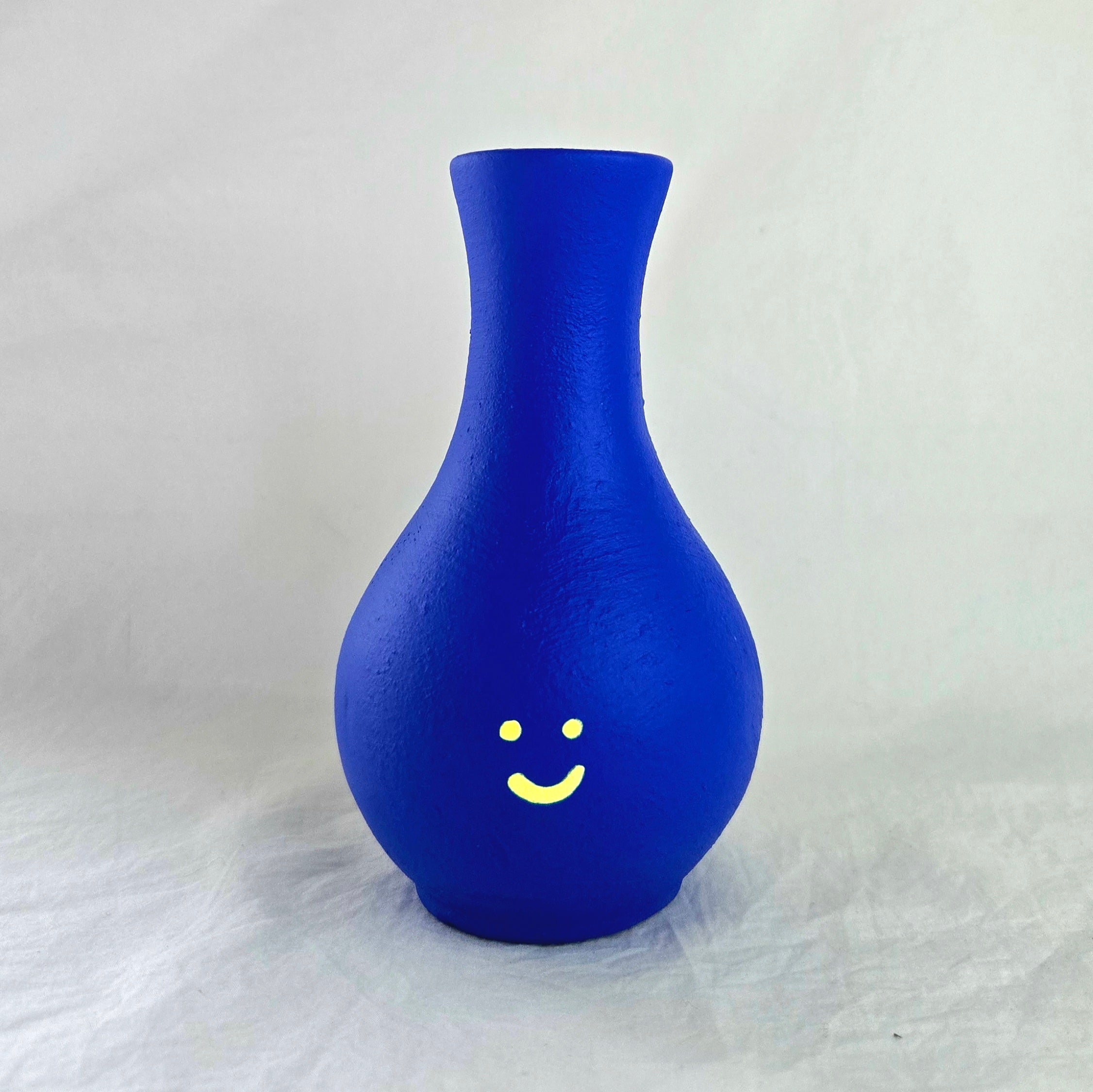 Florero mini en cerámica. Intervenido por cifuentes artista abstracto colombiano titulado HAPPY FLORERO NEON, vista frontal