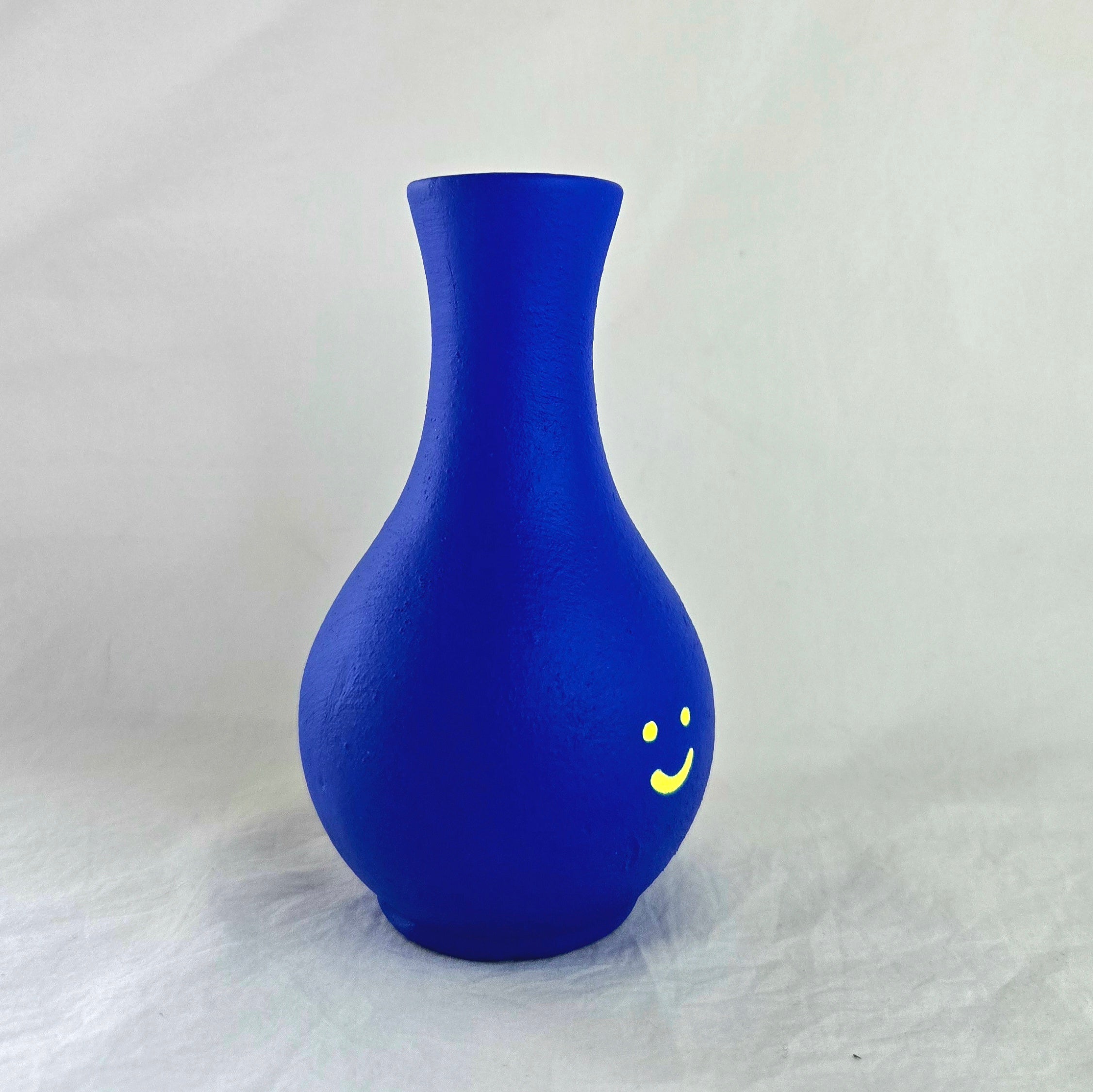 Florero mini en cerámica. Intervenido por cifuentes artista abstracto colombiano titulado HAPPY FLORERO NEON, vista derecha