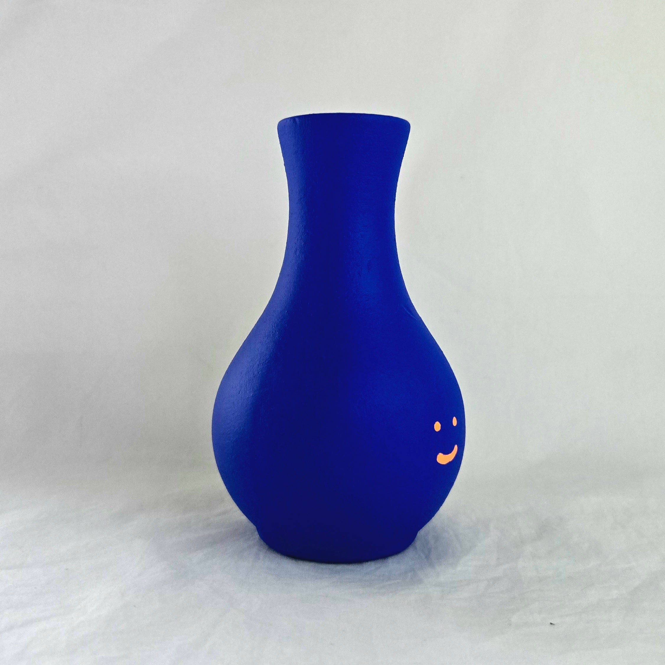 Florero azul en cerámica. Intervenido por cifuentes artista abstracto colombiano titulado HAPPY FLORERO ORANGE, vista derecha