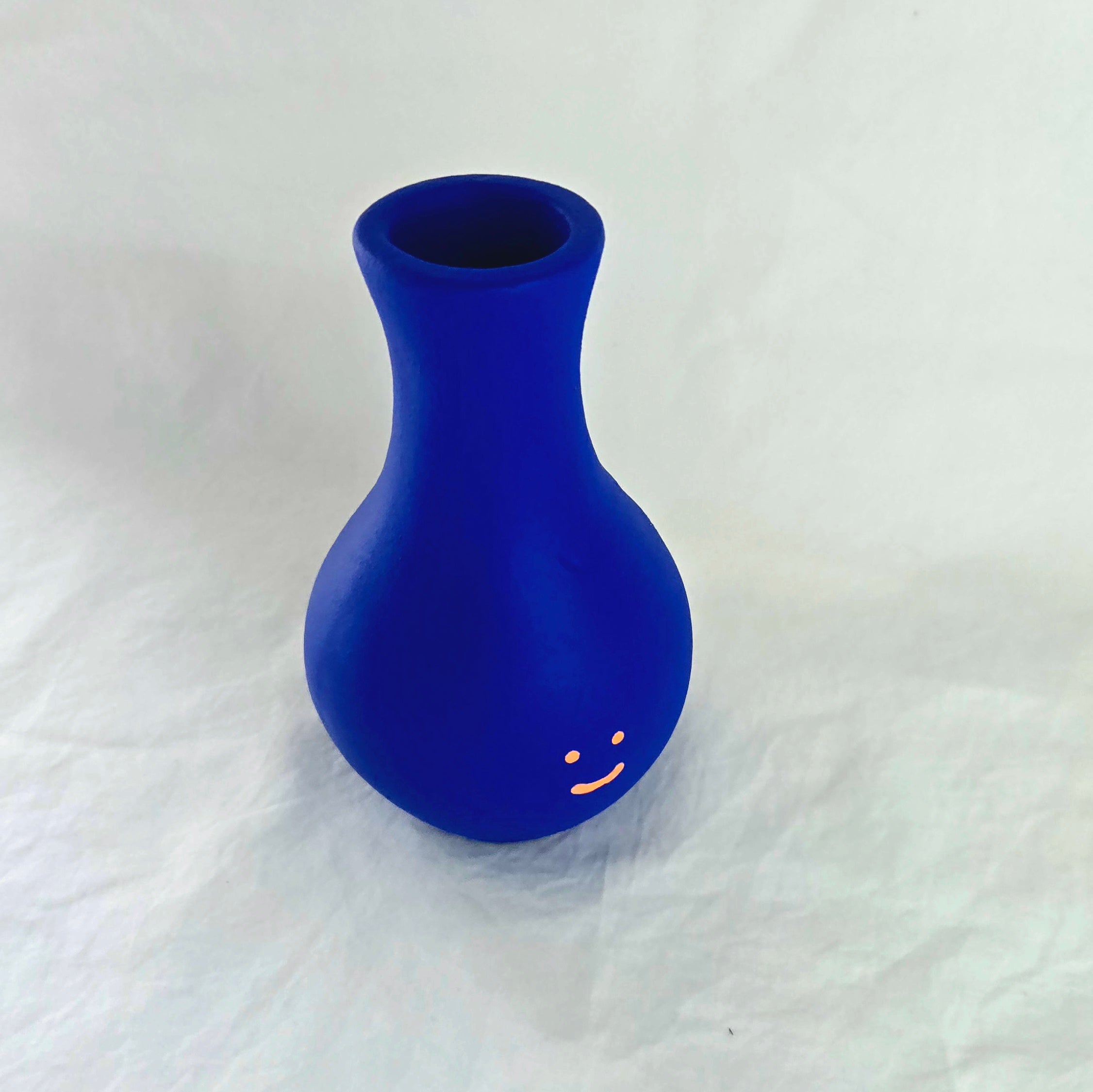 Florero azul en cerámica. Intervenido por cifuentes artista abstracto colombiano titulado HAPPY FLORERO ORANGE, vista desde arriba